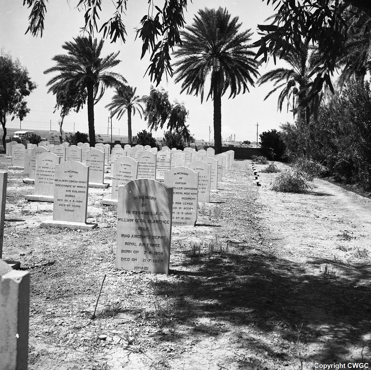 Looking down a grave row towards the perimeter, the headstone of 335488 Leading Aircraftman William Cecil Clarence Self, Iraq Aircraft Depot, Royal Air Force, born 7 June 1904, died 21 July 1927 at Hinaidi, in the foreground. Copyright CWGC.
