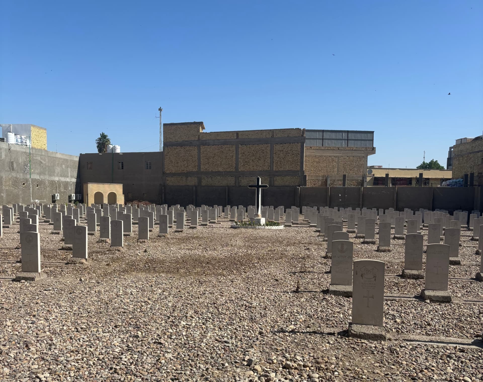 The cemetery looking towards the Cross of Sacrifice. Rather than replace the cross, the top half was bolted onto the bottom half and a cheap metal cross painted gloss black attached to it. The War Stone shown on the original cemetery plan has never been replaced.