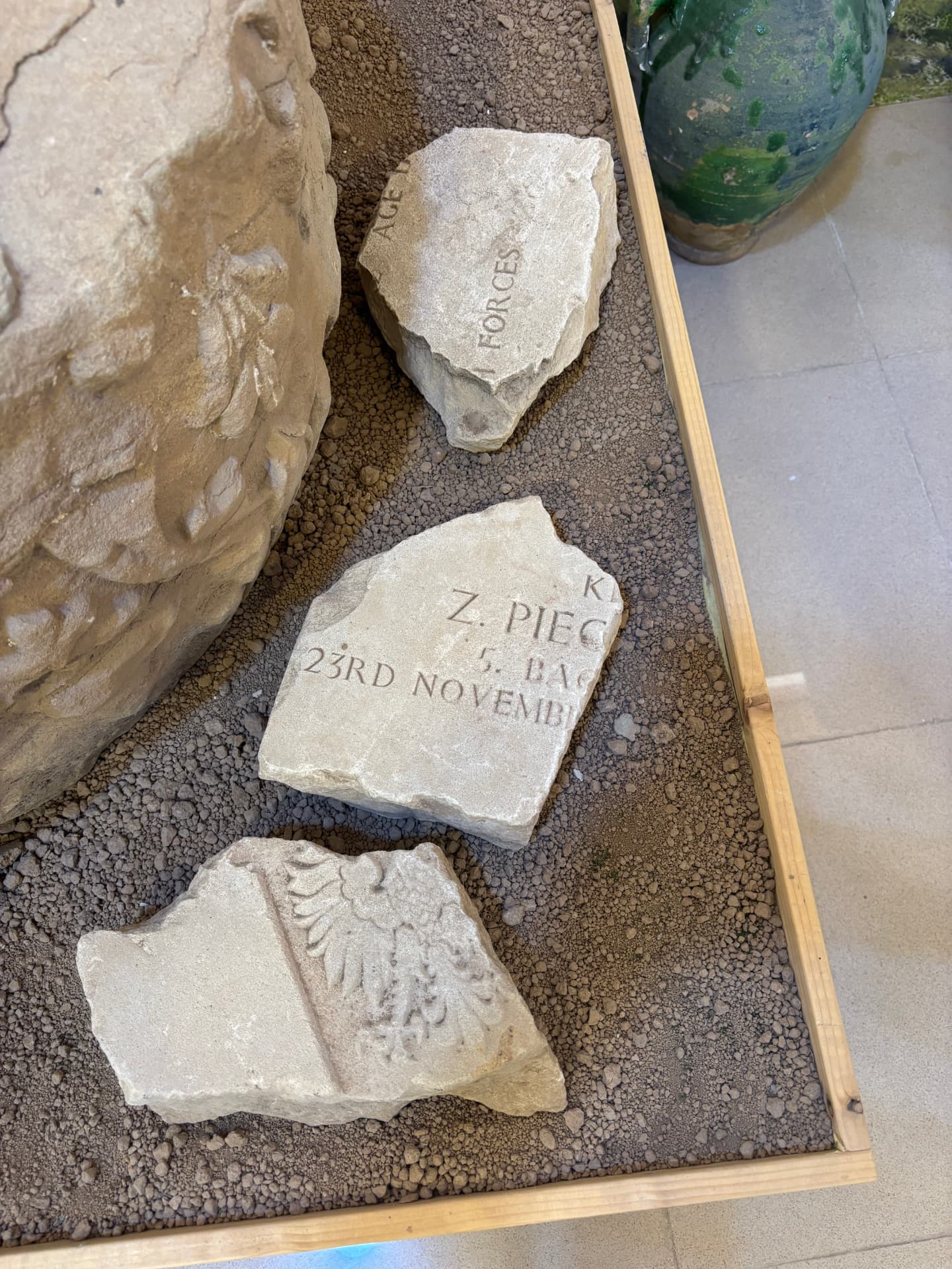 Grave stone fragments from Khanaqin War Cemetery laid out in a display case at the museum, the only surviving pieces of the headstones removed from the site.