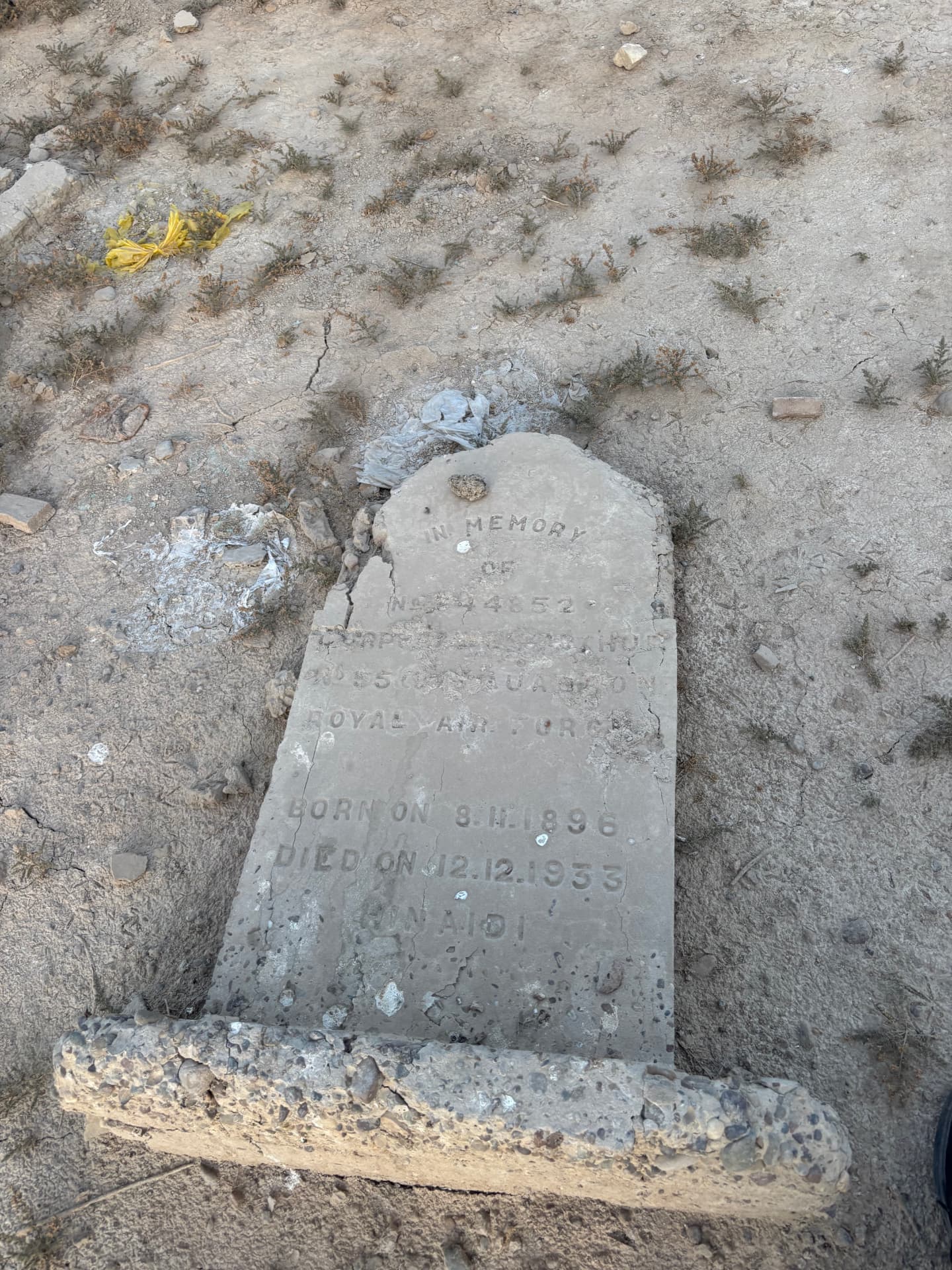 In memory of Corporal Arthur, No. 55 Squadron, Royal Air Force, born 8 November 1896, died 12 December 1933, Hinaidi. The headstone lies flat and broken on the open ground.