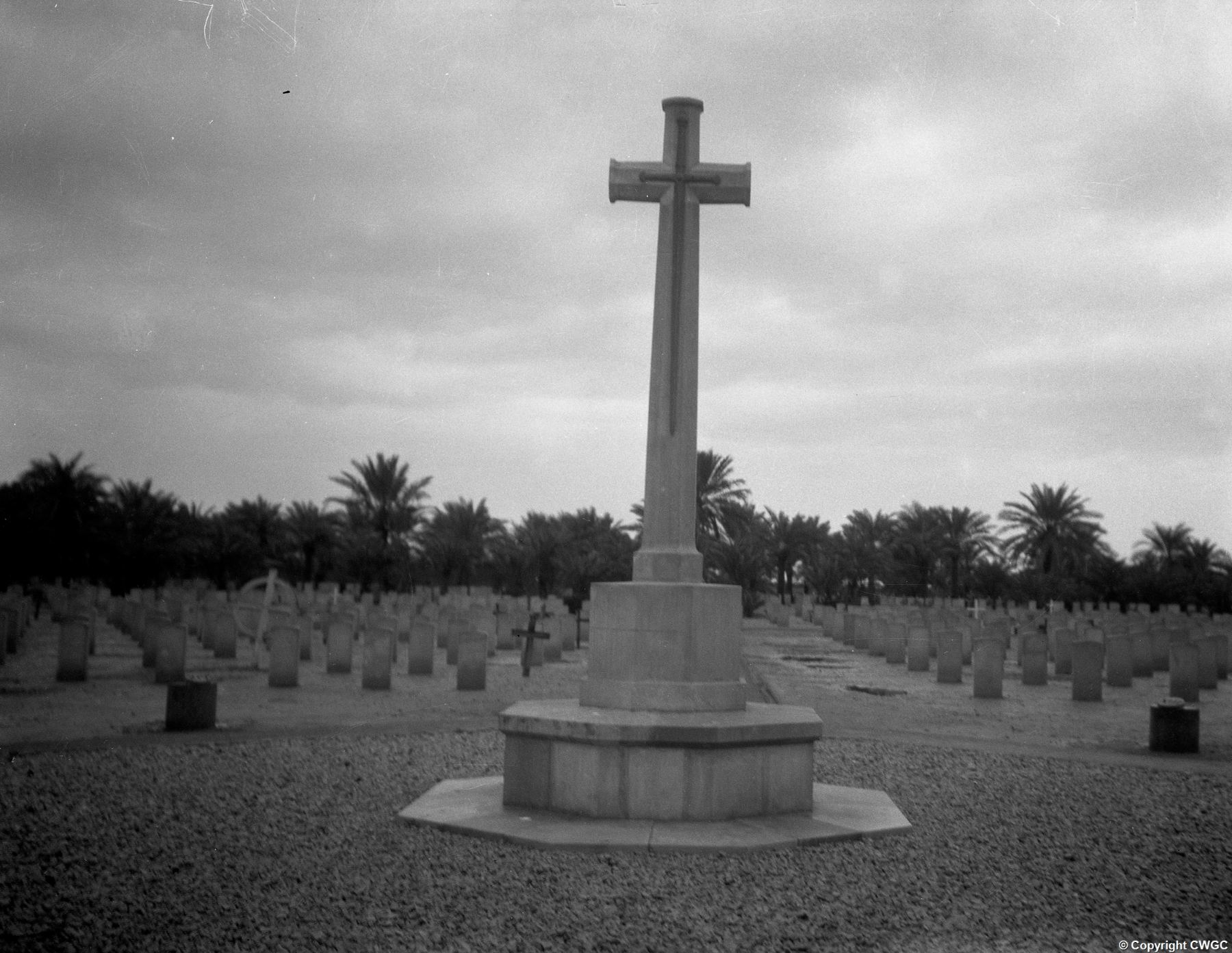 The Cross of Sacrifice in its original condition, standing at the head of the original headstones before they were removed and replaced by the Memorial Wall in the 1930s. © CWGC.