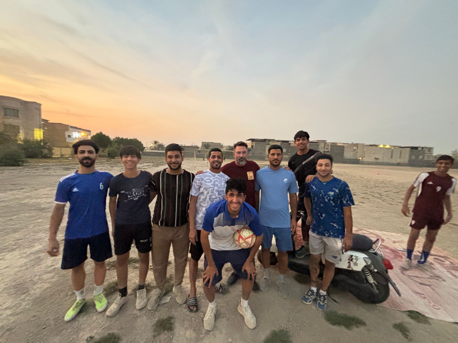 Local young men of the Al Hakameia neighbourhood gathered at sunset on the bare ground of Basra War Cemetery, which they use regularly as a football pitch.