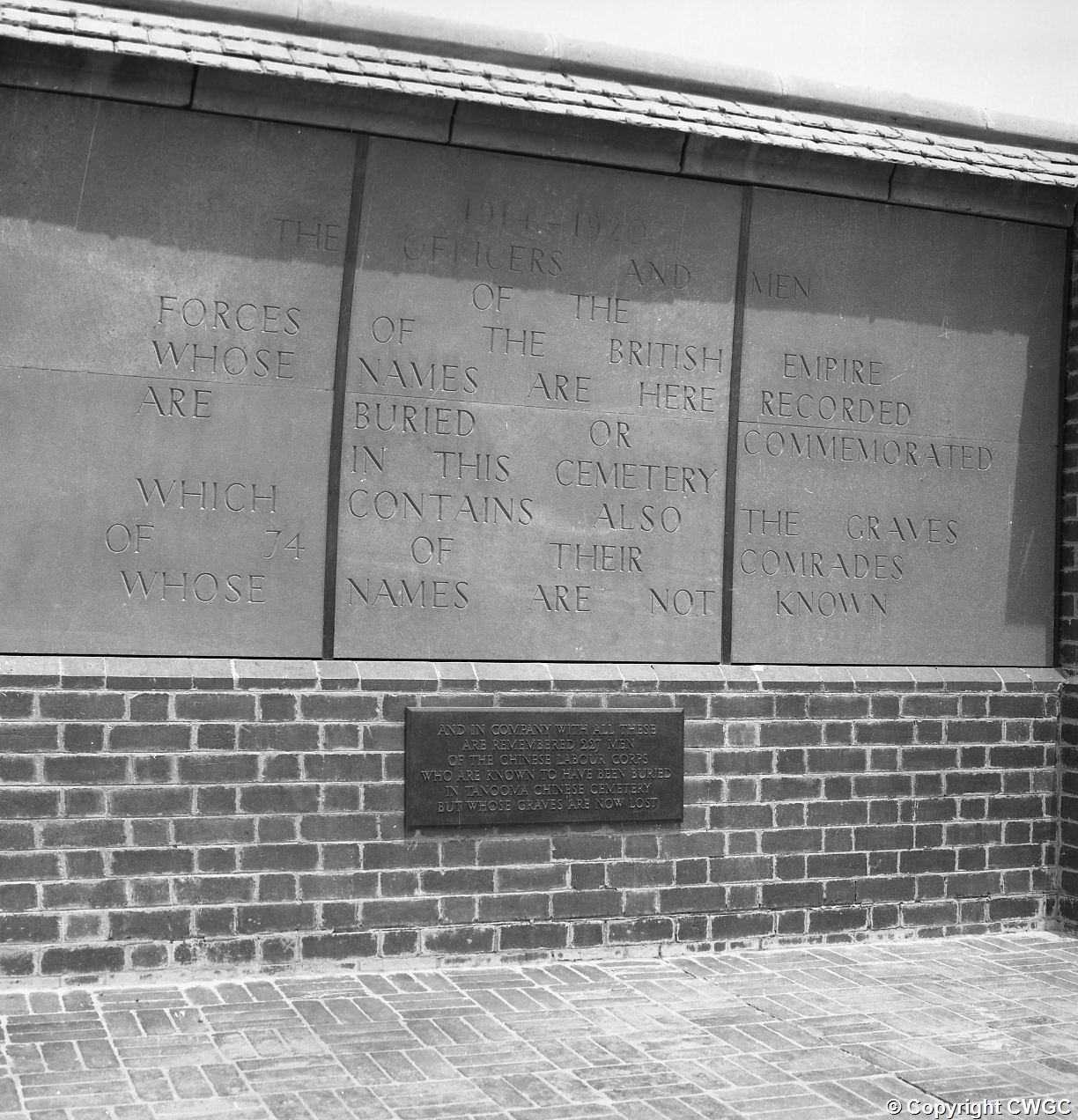 The Tanooma Chinese Memorial panel set within the Memorial Wall at Basra War Cemetery, with the bronze plaque below recording the 227 men of the Chinese Labour Corps known to have been buried in Tanooma Chinese Cemetery whose graves are now lost.