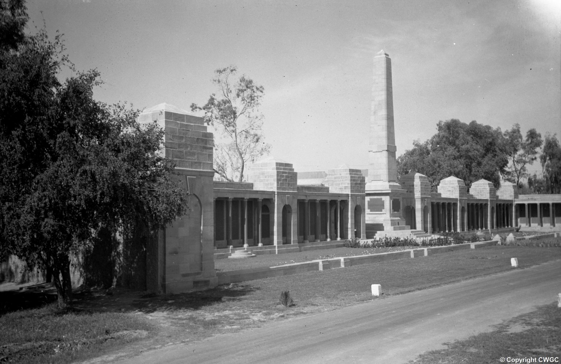 The Basra Memorial soon after completion, with the central obelisk rising above the colonnaded screen wall and pavilions, viewed from the approach road. © CWGC.