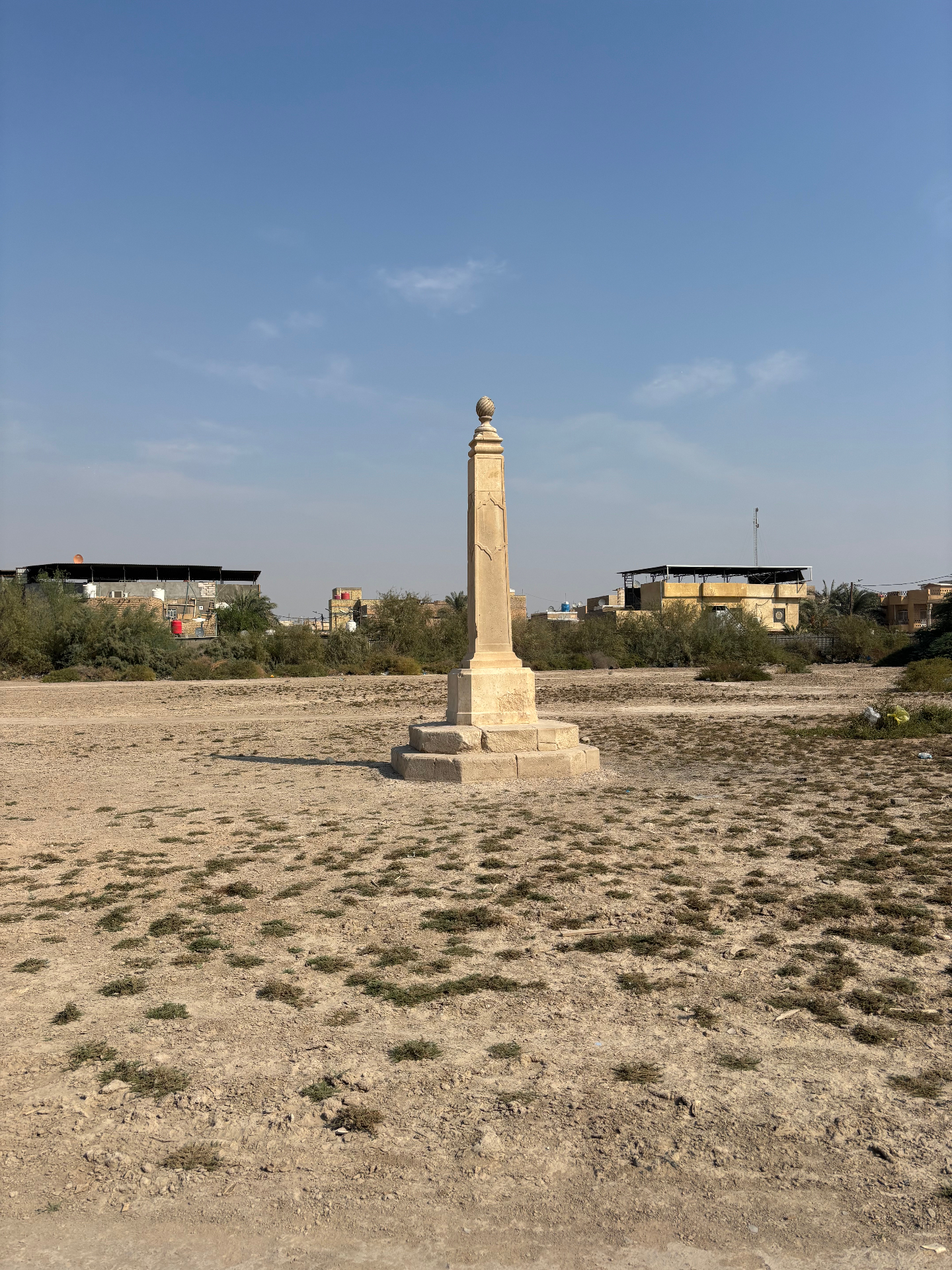 The obelisk on the Indian Forces side of Basra War Cemetery, standing alone on bare, scrub-covered ground where rows of headstones once stood. Photo: Shane Potaka.