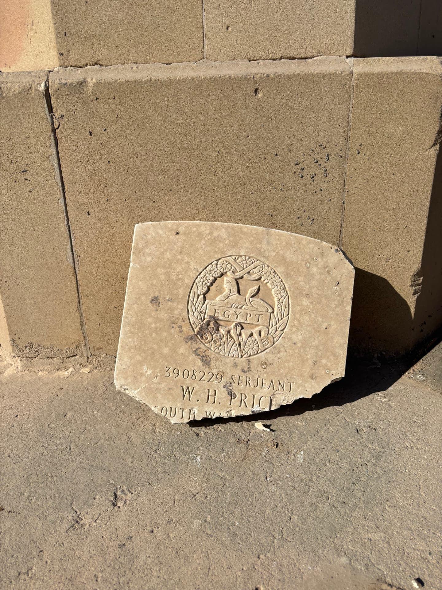 The sole surviving grave fragment at Mosul War Cemetery, propped against the base of the perimeter wall, carrying the South Wales Borderers badge and the inscription "3908229 Serjeant W. H. Price, South Wales Borderers".