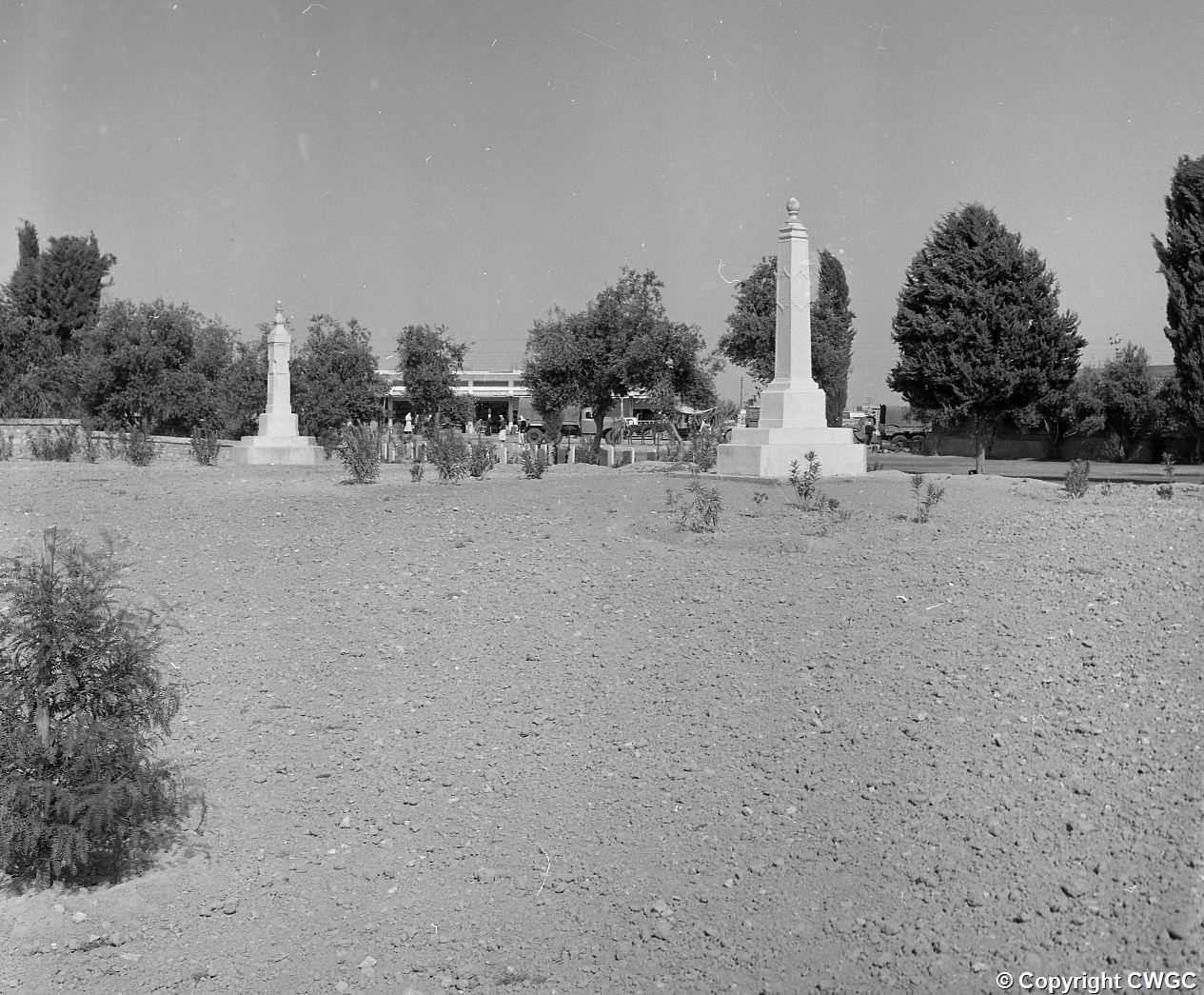 The two Indian memorial obelisks, to the Muslim and to the Hindu and Sikh casualties, standing at the edge of newly worked ground. © CWGC.