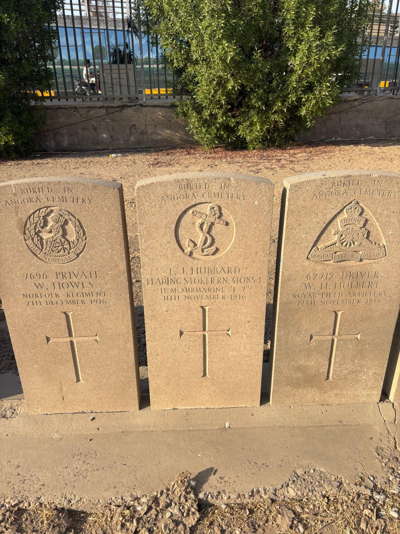 Three headstone-style memorials at Baghdad Northgate for men originally buried in Angora Cemetery: Private W. Hows of the Norfolk Regiment, Leading Stoker J. J. Hubbard of HM Submarine J7, and Driver W. H. Hulbert of the Royal Field Artillery.